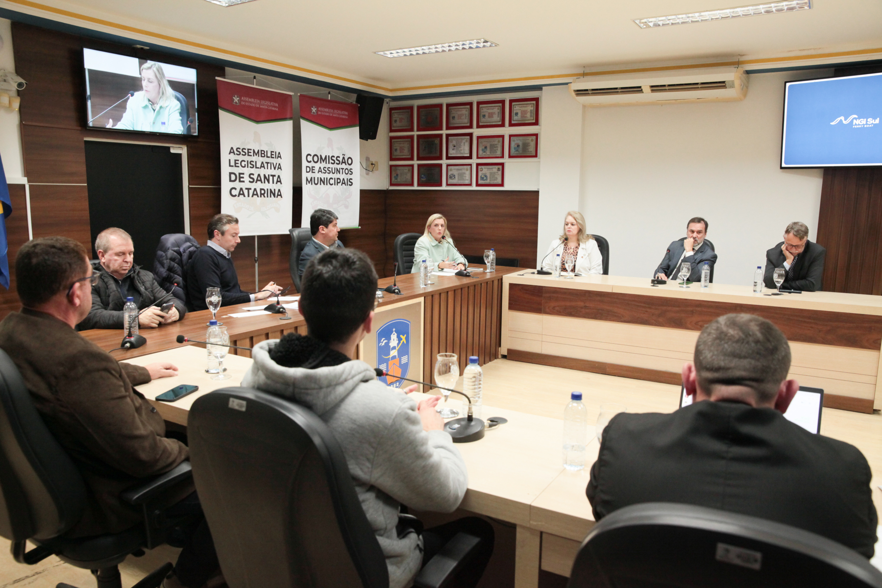 ambiente interno, 10 pessoas sentadas em tribuna