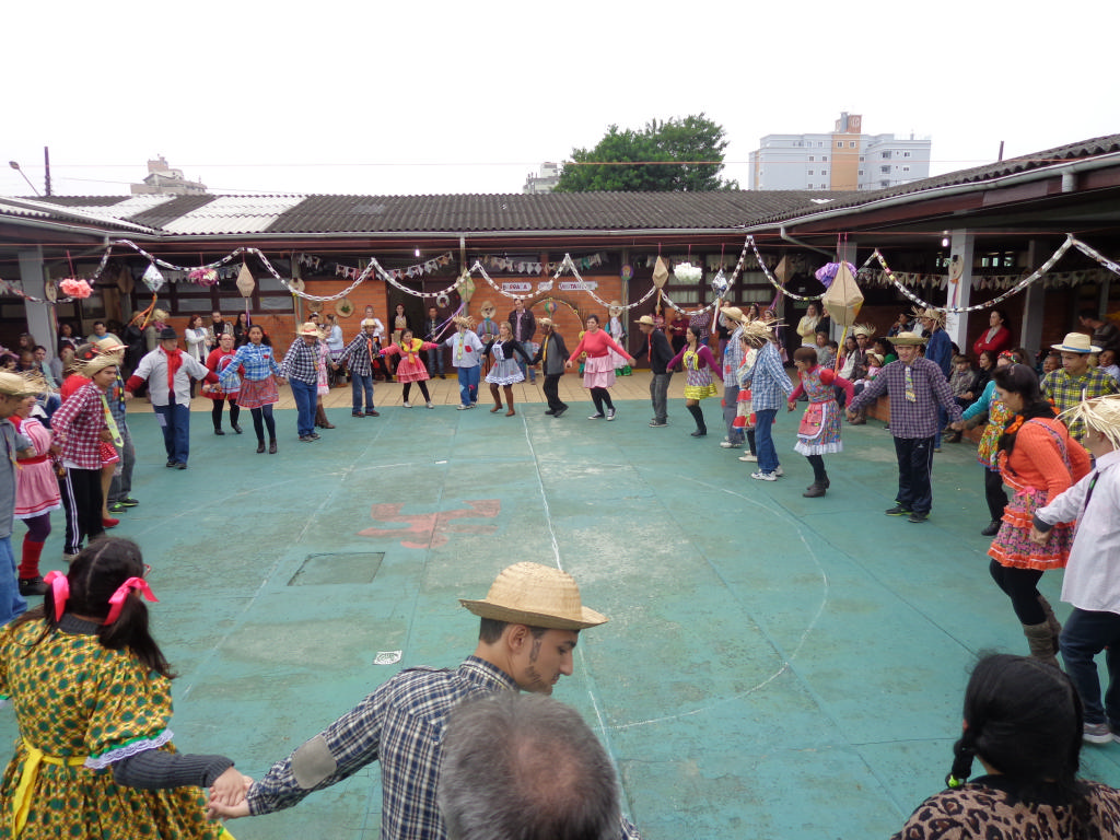 Arraia da FCEE -  dança da quadrilha pessoas dando as mãos fazendo uma roda gigante.