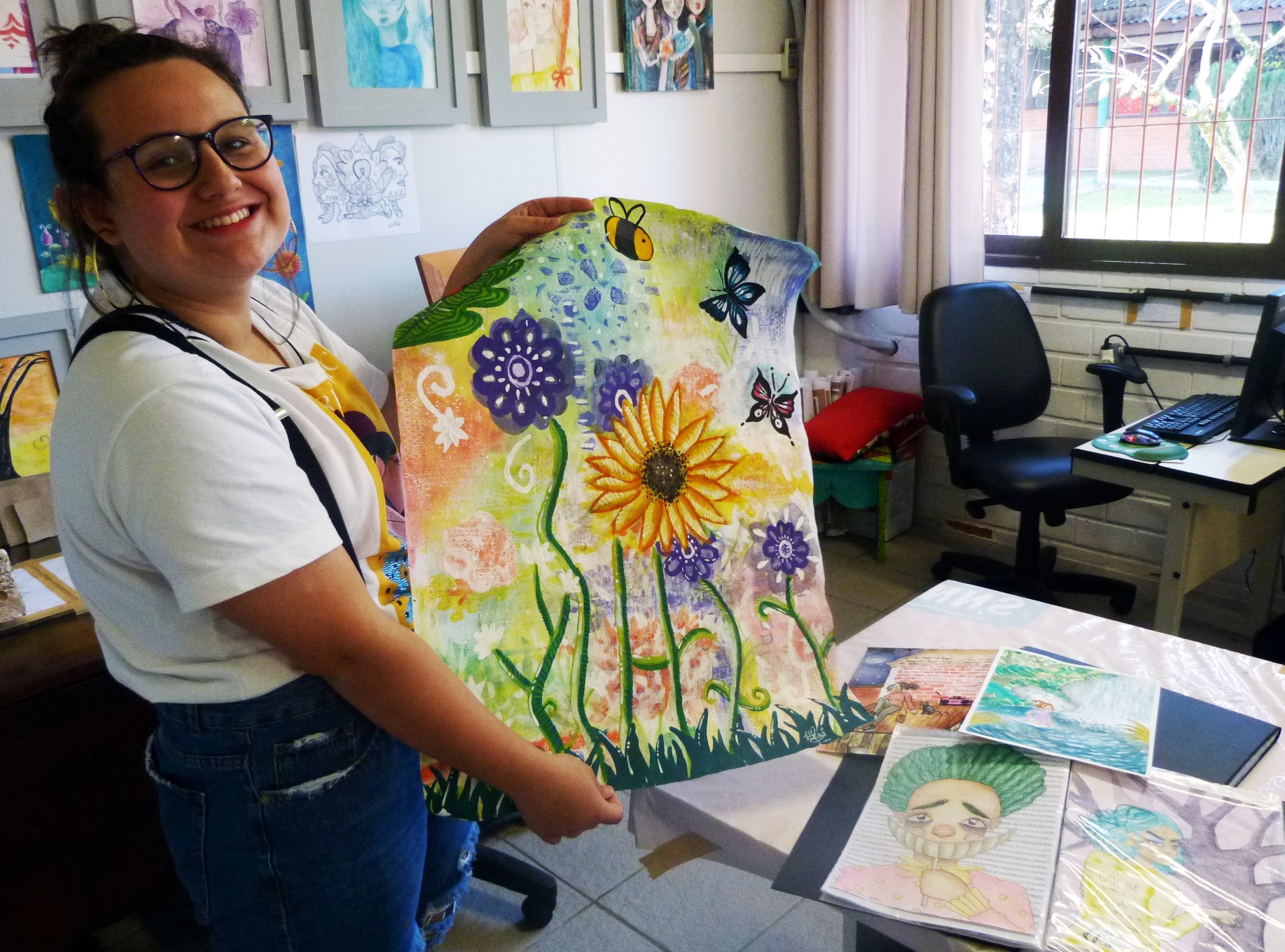 Júlia mostrando suas pinturas em aquarela. 