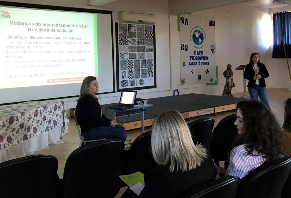 Profissionais da FCEE falam diante do público em sala de aula lotada.