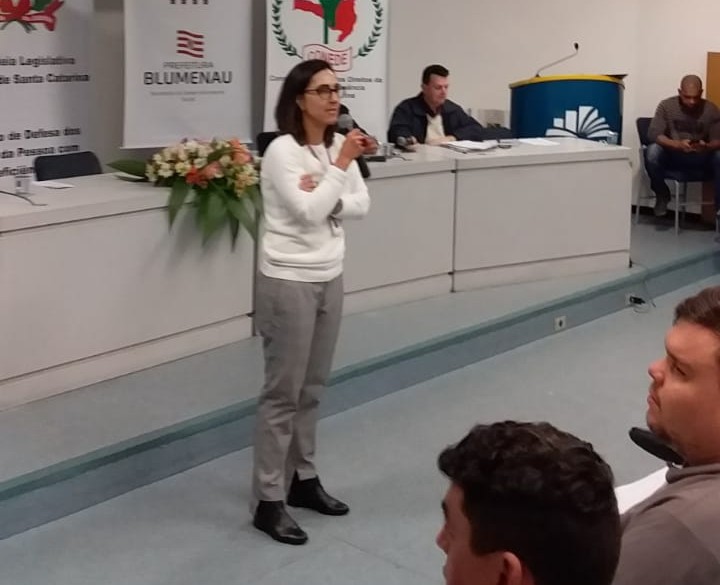 Pedagoga Márcia Lemhkul falando ao microfone durante encontro do Conede