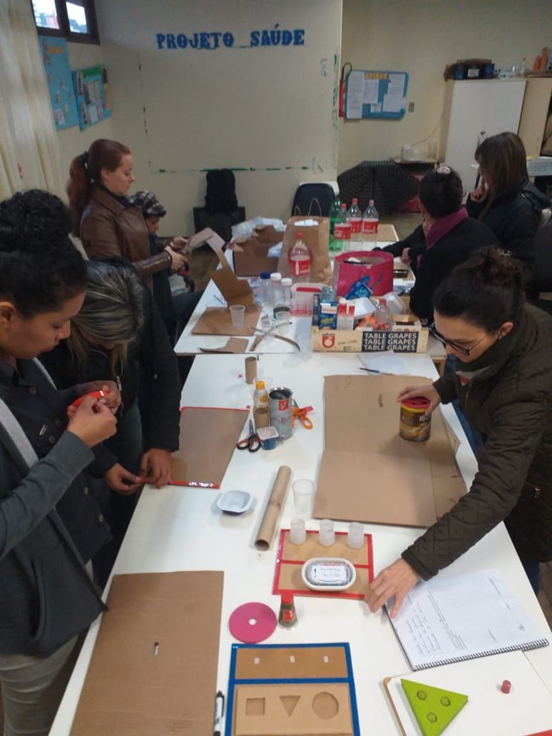 Professores do CEVI e do CETEP em volta de mesa produzindo materiais pedagógicos adaptados