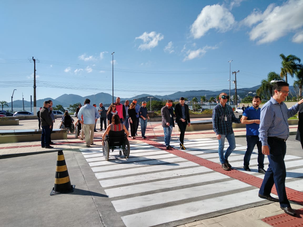 Gestores da Justiça Federal atravessam faixa de segurança com vendas nos olhos e em cadeiras de rodas