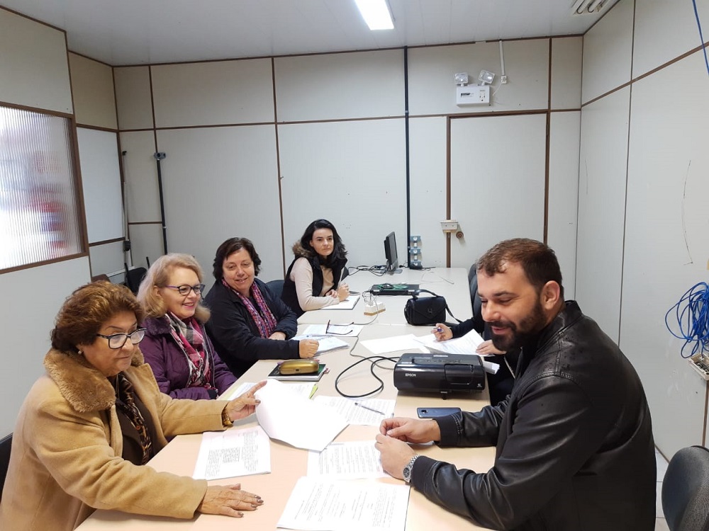 Servidores reunidos em torno de mesa de reunião