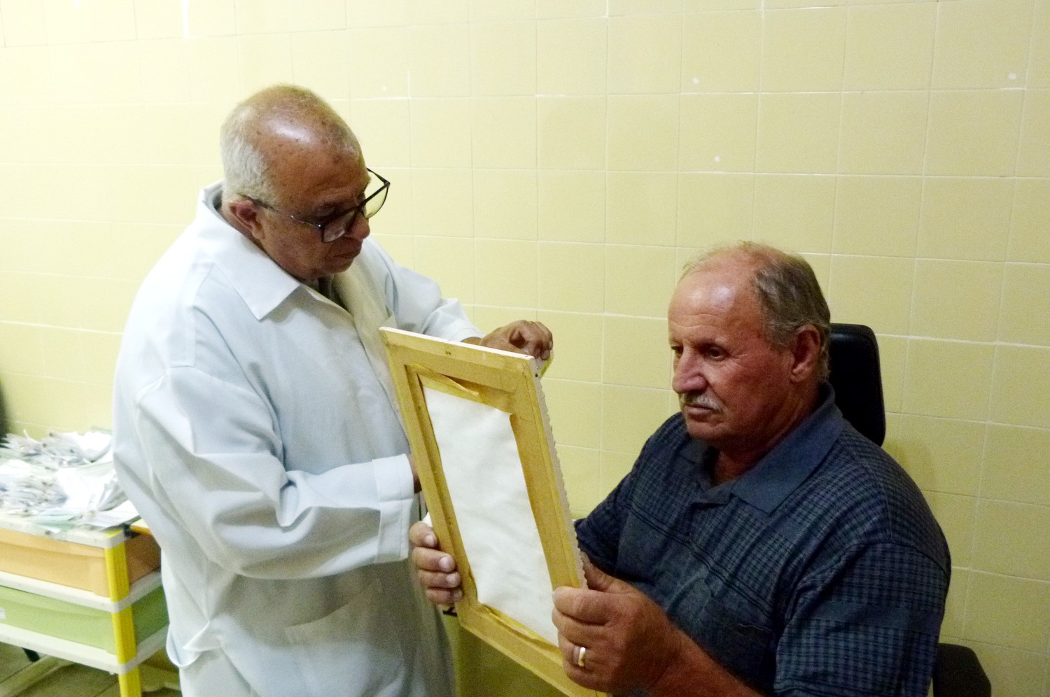 Paciente sentado ao lado de técnico se olha no espelho