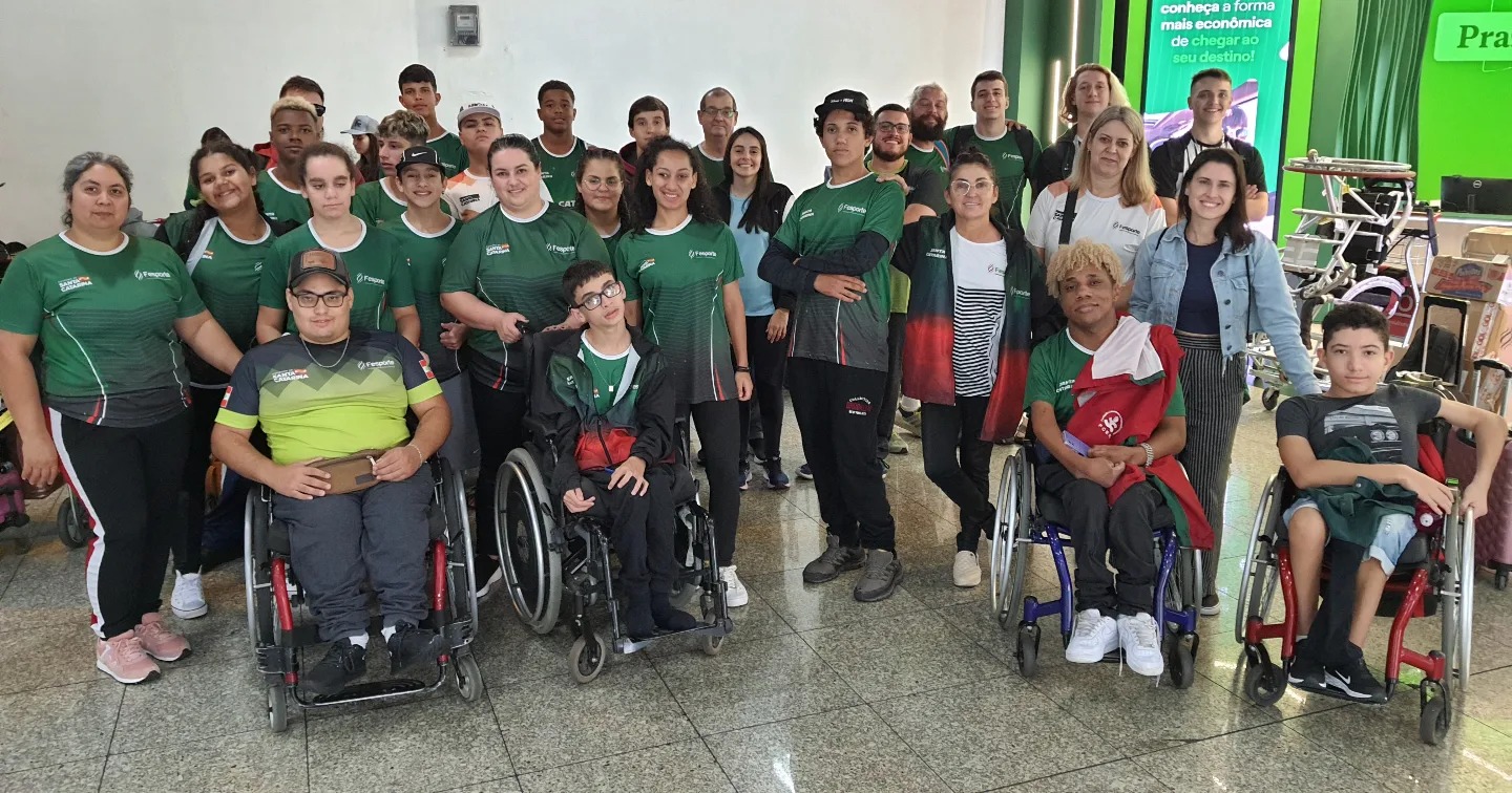 Vinte pessoas, alguns cadeirantes, posam para foto