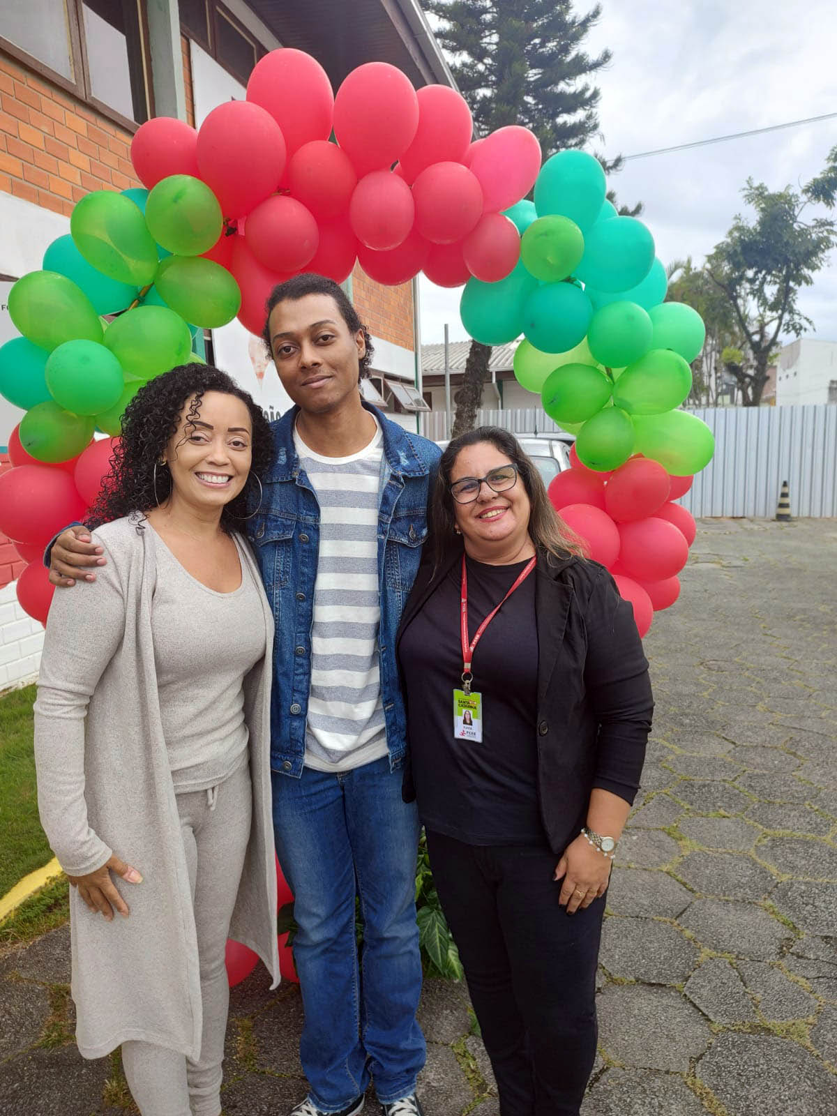 3 pessoas posam para foto ambiente externo